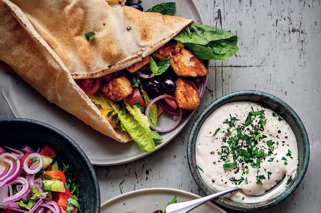 Kryddig halloumi, kripspiga grönsaker och vitlökssås som serveras i tortillabröd. Så gott! Här är ett enkelt recept ur boken Vego på 15 minuter.