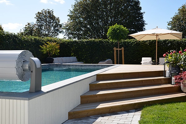 En pool ovan mark, här inramad av ett trädäck med trappa.