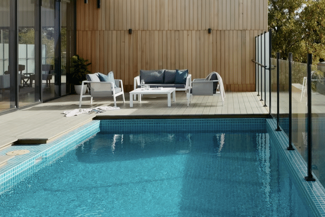 Glasräcken kan vara praktiskt runt poolen om man behöver vindskydd men vill behålla utsikten. Foto: Unsplash