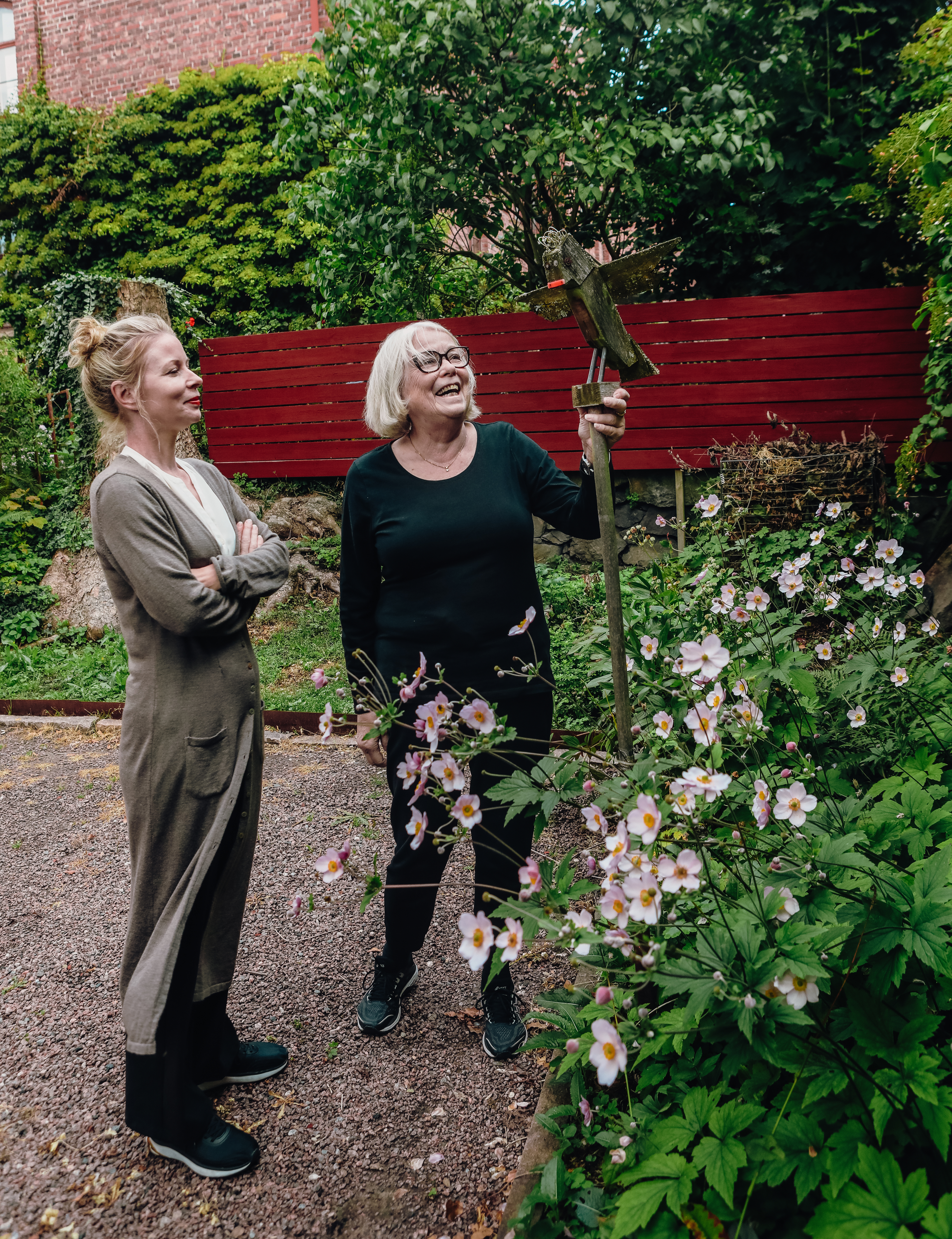 Julia och Lena ser på en träfågel gjord av Carl Eric.